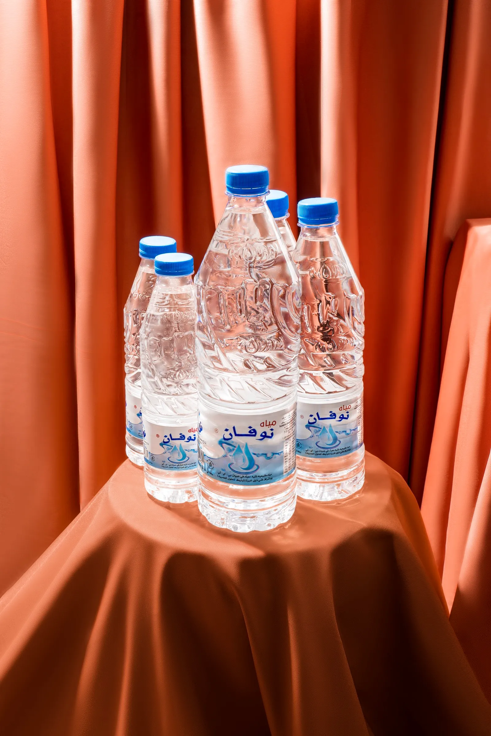 Novan bottles grouped on a draped terracotta cloth