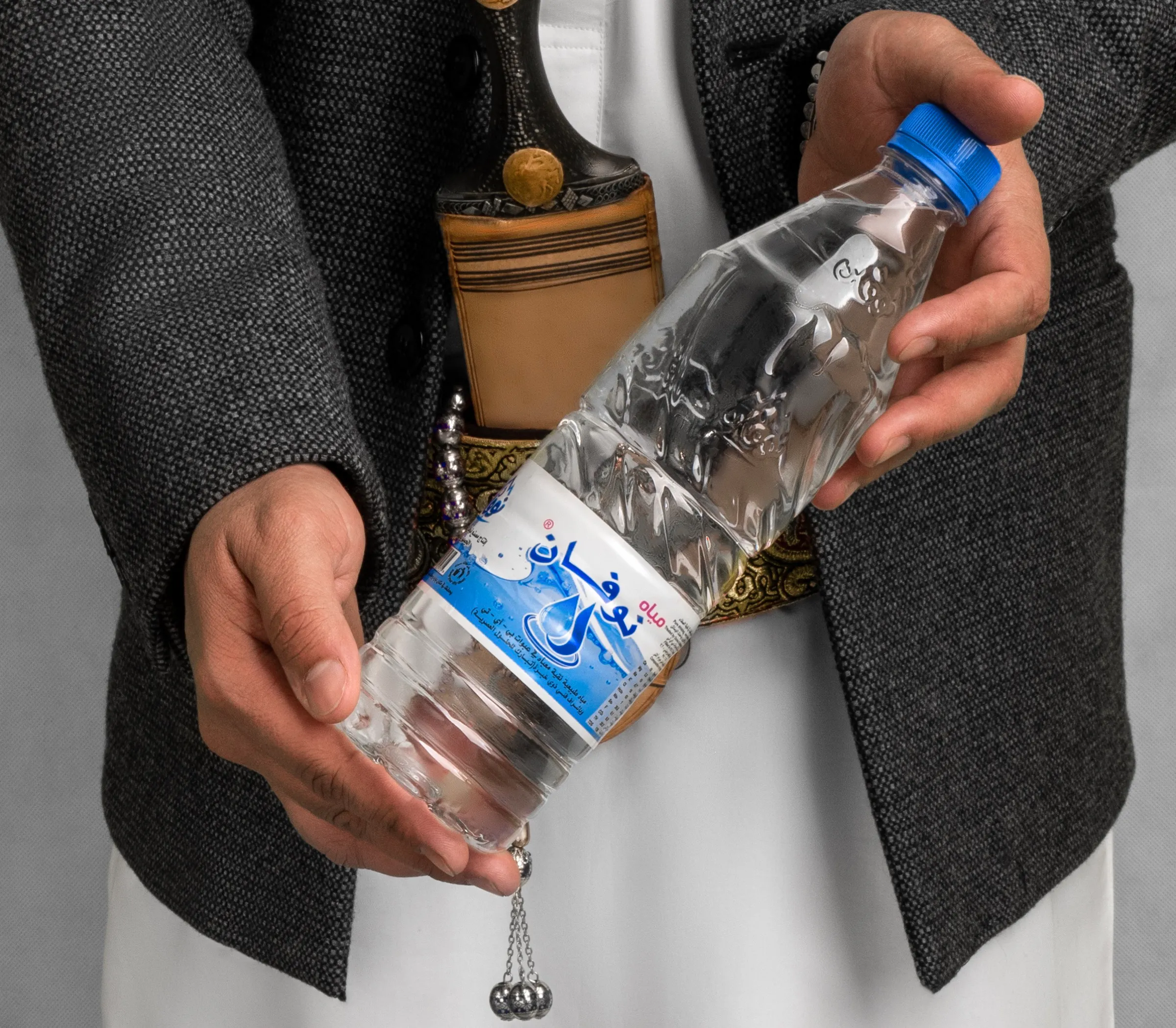 Novan bottle held with pride in traditional Yemeni dress
